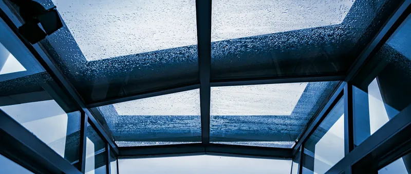Cobertura translúcida vista de baixo, com gotas de chuva sobre as chapas